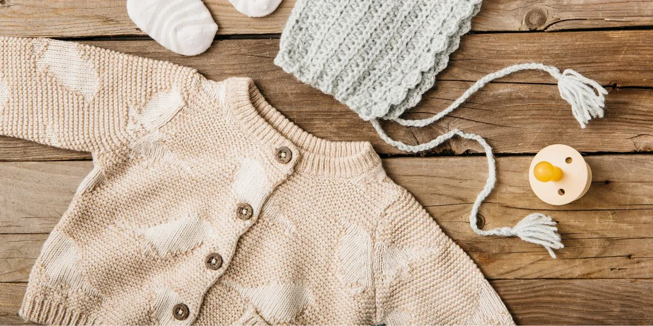 Bannière comportant un cardigan rose avec des oiseaux, un bonnet, une tétine et des chaussettes