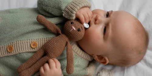 Bébé couché portant sa peluche